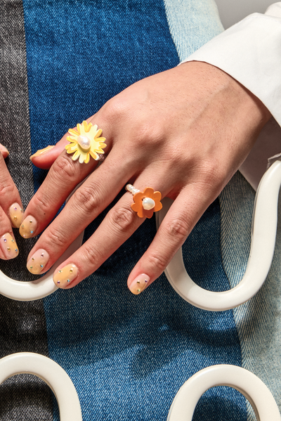 Model wears Bianca Mavrick Pearl Flower and Hand-painted Daisy Rings