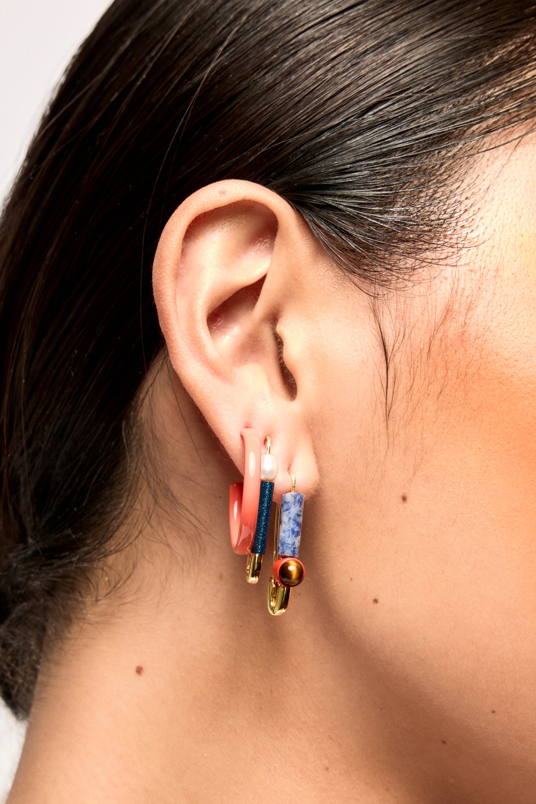 A model wearing Bianca Mavrick Jewellery safety pin earrings and colour hoops
