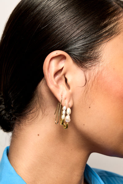 Model wears Bianca Mavrick Jewellery Safety Pin Earrings Gold Mismatched Pearls 