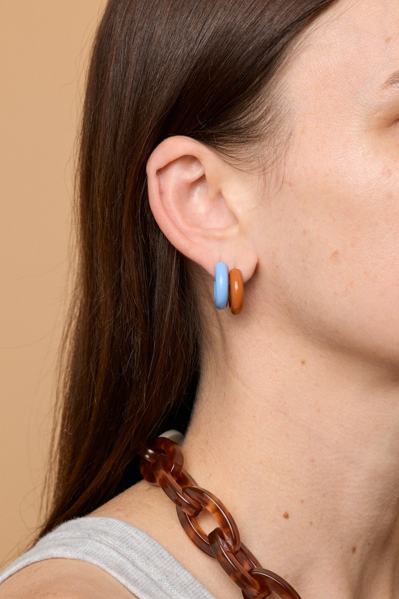 Bianca Mavrick Jewellery model wearing layered enamel hoop earring powder blue and terracotta